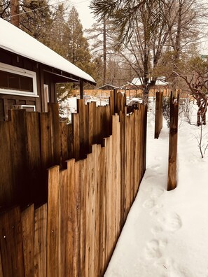 A wooden fence with snow on the ground.