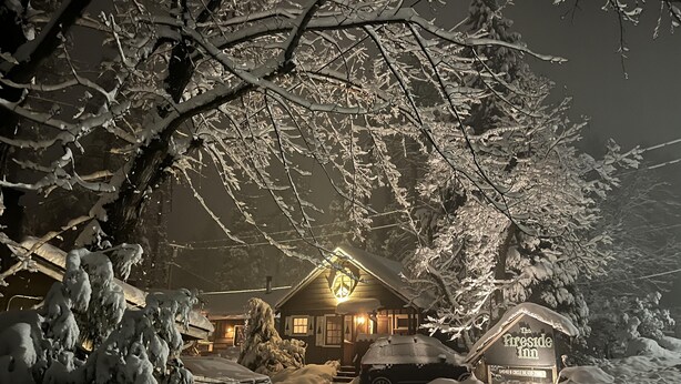 A snow-covered lodge with a lit sign reading "The Pineside Inn." - The Fireside Inn (Idyllwild)