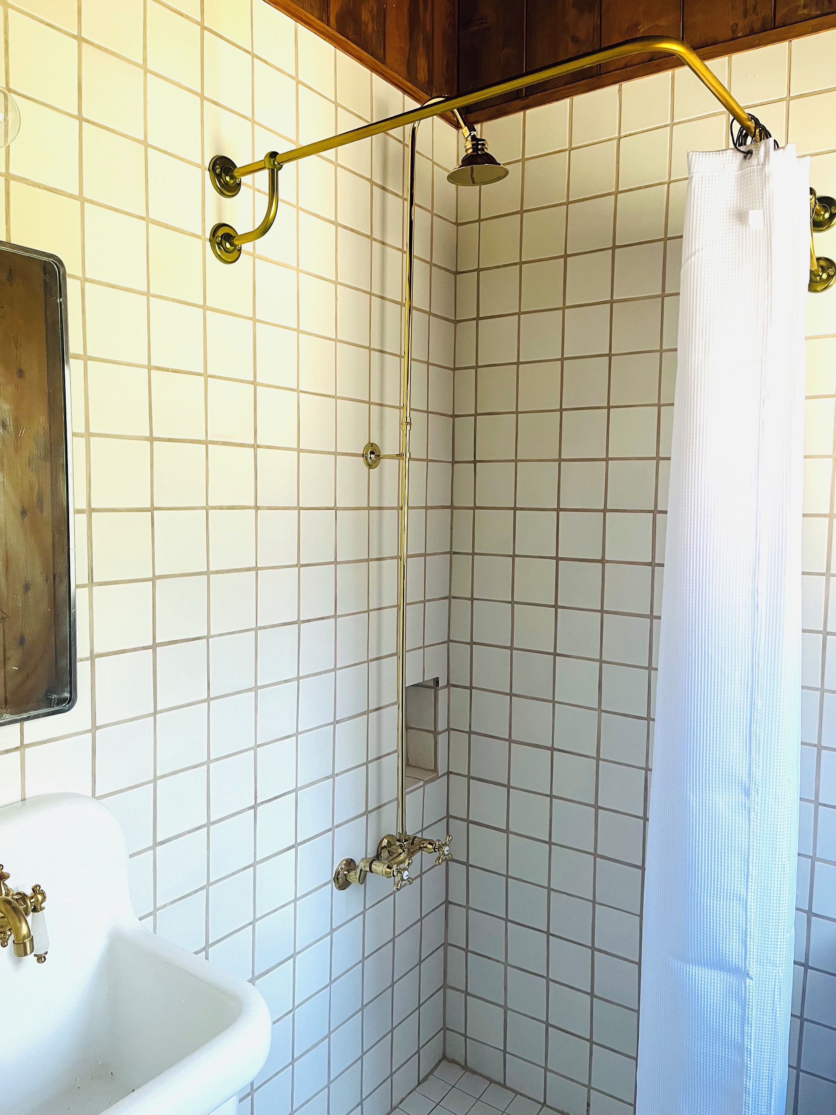 A bathroom with a shower, a sink, and a mirror.
