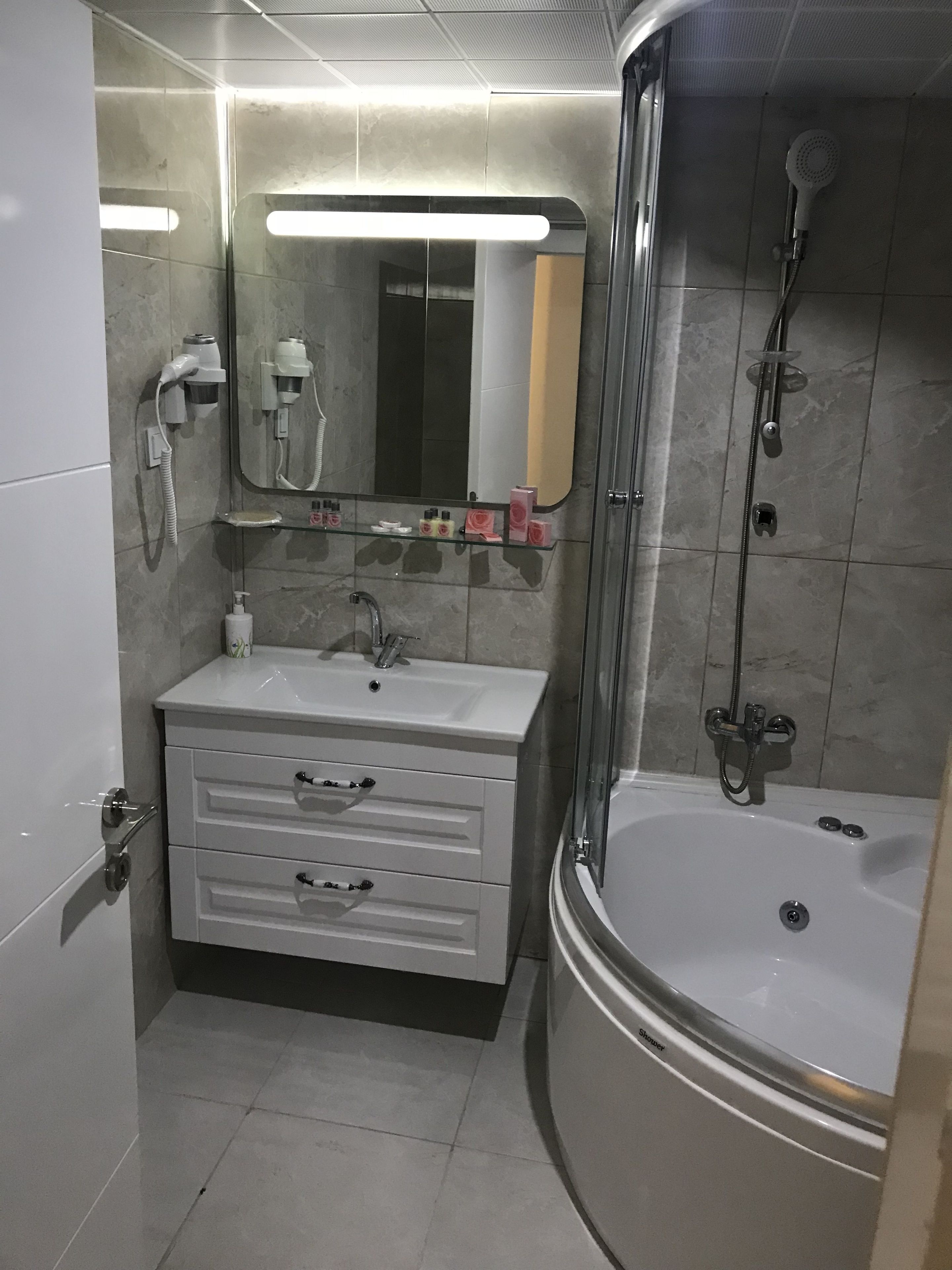 Un baño moderno con tocador, espejo, ducha y bañera.