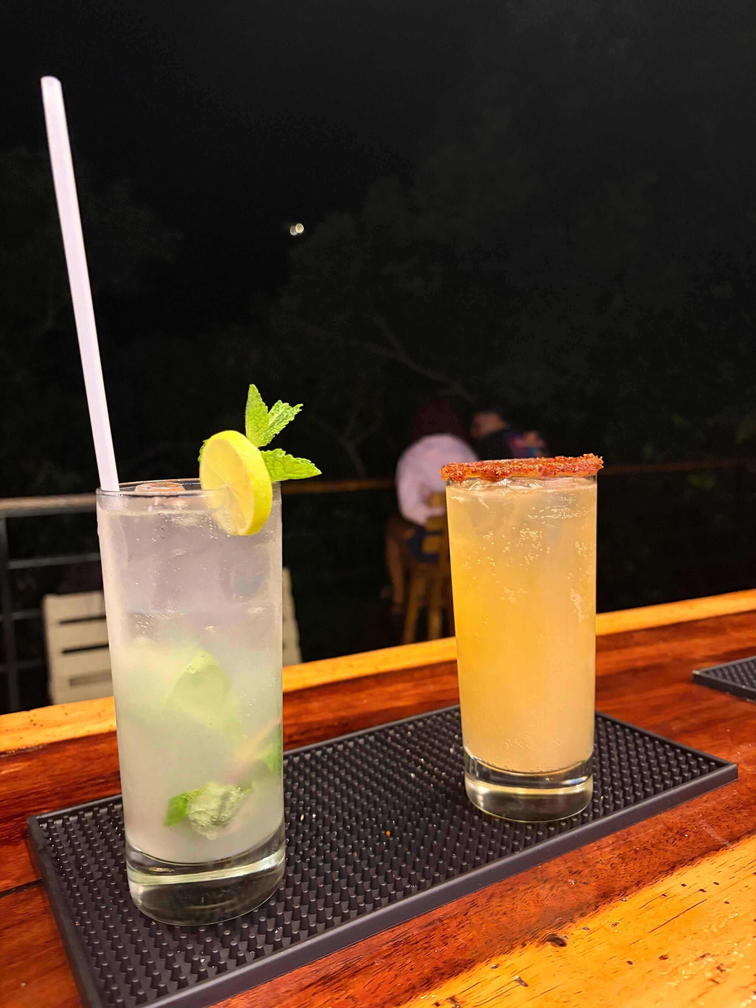 Deux boissons sur une table, avec un fond sombre.