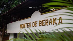 Une enseigne avec l’inscription « MONTES DE BERAKA » en lettres dorées sur un fond blanc.