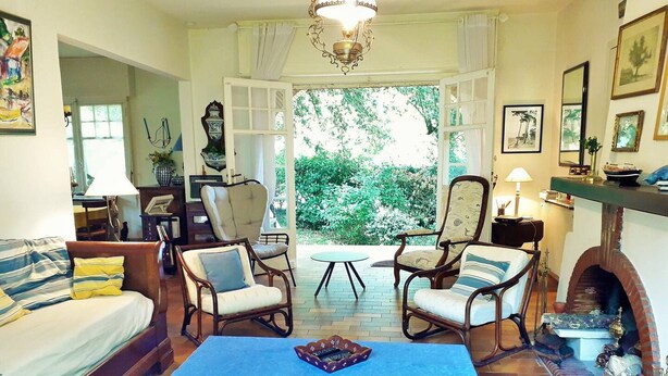 Un salon chaleureux avec un canapé, deux fauteuils, une table basse et une cheminée.