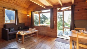 Interior de una cabaña de madera con un sofá, una mesa y un banco.
