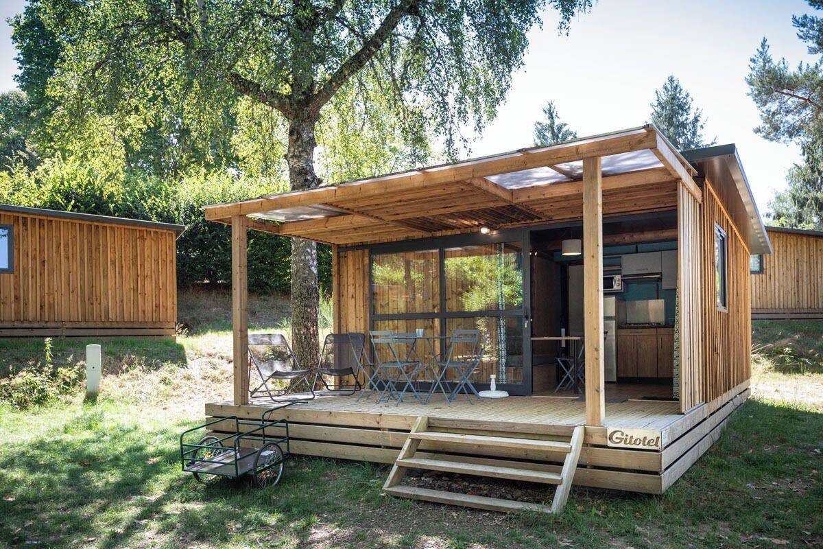 Une cabane en bois dotée d’un patio couvert, d’un espace salon extérieur et d’une cuisine ouverte.