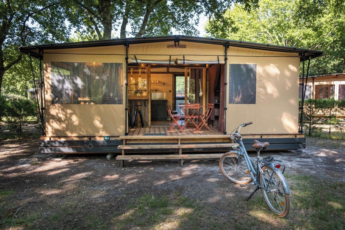 Une maison mobile dotée d’un porche abrité, d’un vélo et d’un coin repas.