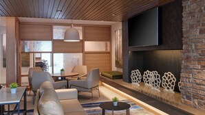 Un salon moderne avec un canapé, des fauteuils, une table basse et une cheminée.