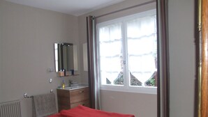A bedroom with a bed, a dresser, a mirror, and a window with curtains. - House in Balearic resort at 900 m. from the beach and shops (Jullouville)