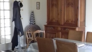 A dining area with a checkered floor, wooden chairs, a table, and a hanging light fixture. - House in Balearic resort at 900 m. from the beach and shops (Jullouville)