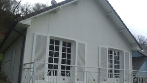 A two-story house with a balcony, white shutters, and a satellite dish. - House in Balearic resort at 900 m. from the beach and shops (Jullouville)