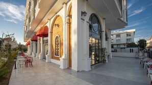 A hotel with outdoor seating, large windows, and a tiled patio. - The Sansa Hotel & Spa (Manavgat)