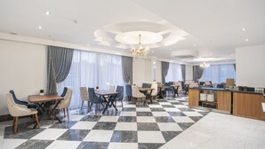 A spacious hotel dining area with checkered flooring, multiple dining tables, and chairs. - The Sansa Hotel & Spa (Manavgat)