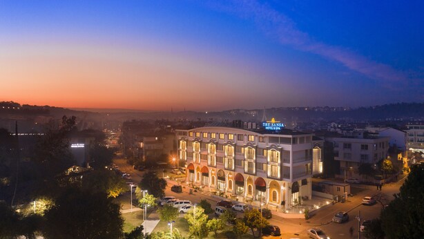 A hotel with a prominent sign, multiple floors, and a parking area. - The Sansa Hotel & Spa (Manavgat)