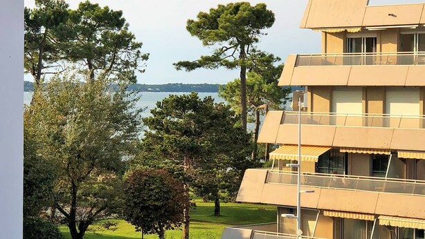 A multi-story building with balconies overlooking a body of water.
