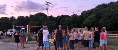 A group of people standing outdoors at dusk.