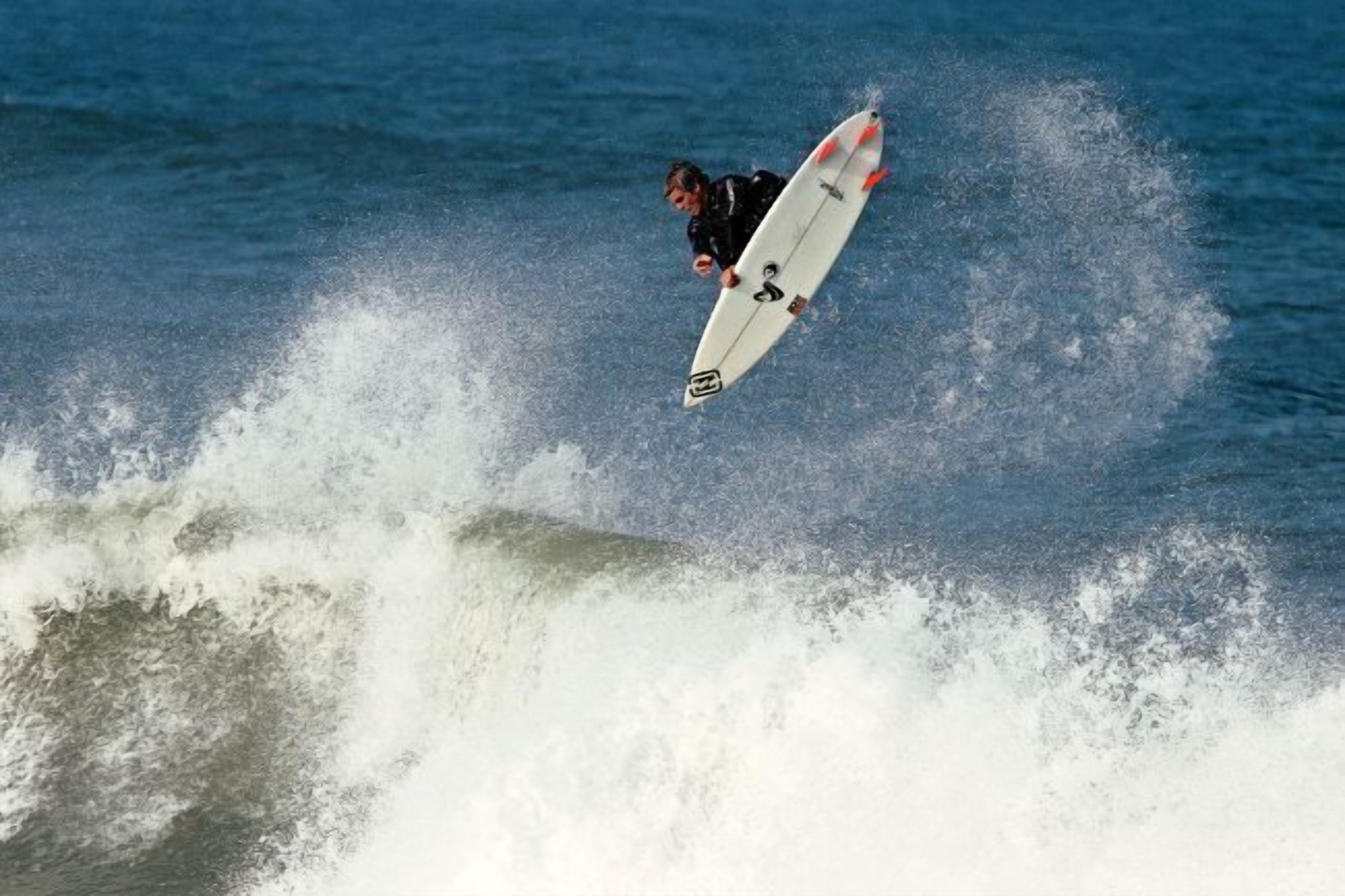 A surfer performing a trick on a wave.