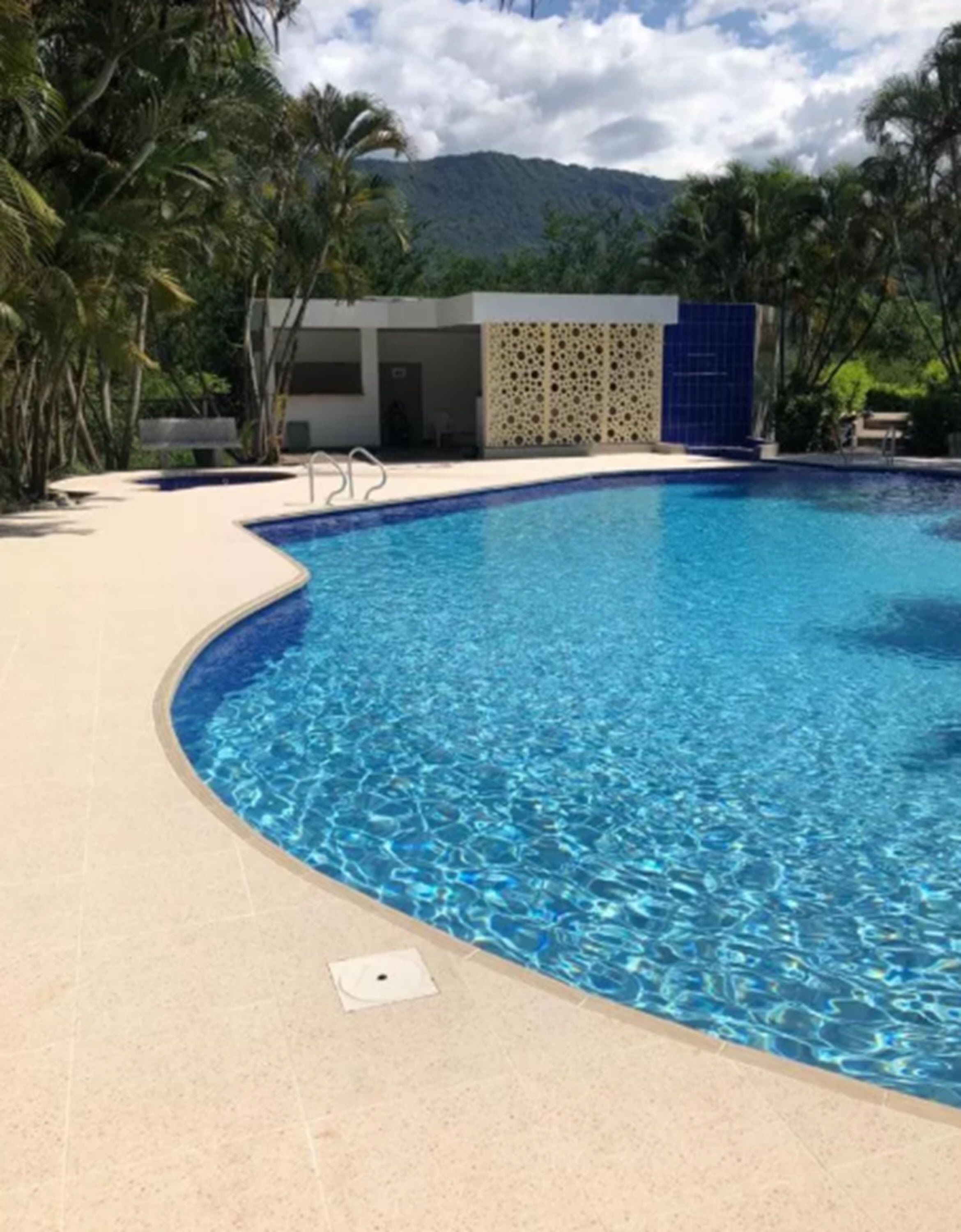 Una piscina al aire libre, sillones reclinables de piscina