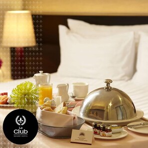A hotel room with a neatly arranged breakfast buffet, including pastries, fruits, and a variety of spreads. - Le Club Resort Hotel (Encarnacion)