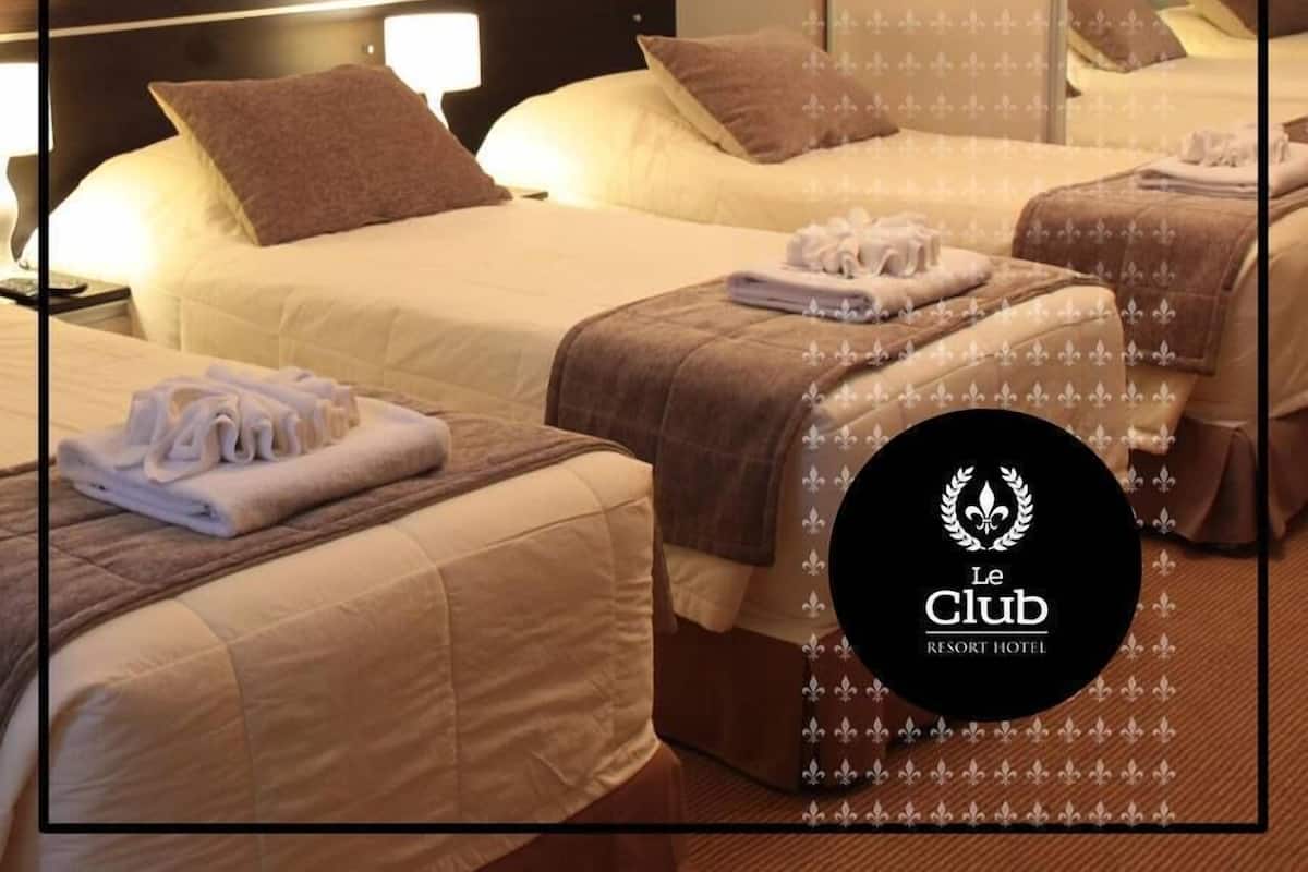 A hotel room with two beds, a nightstand, and a mirror.