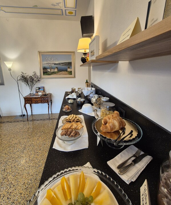 Un buffet de petit-déjeuner proposant divers aliments, un tableau accroché au mur et une lampe.