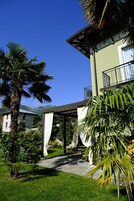 A building with a covered outdoor area, a palm tree, and a clear blue sky.