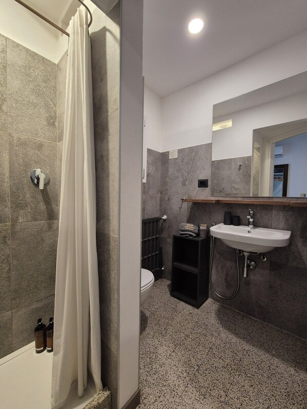 Une salle de bain moderne équipée d’une douche, de toilettes et d’un lavabo.