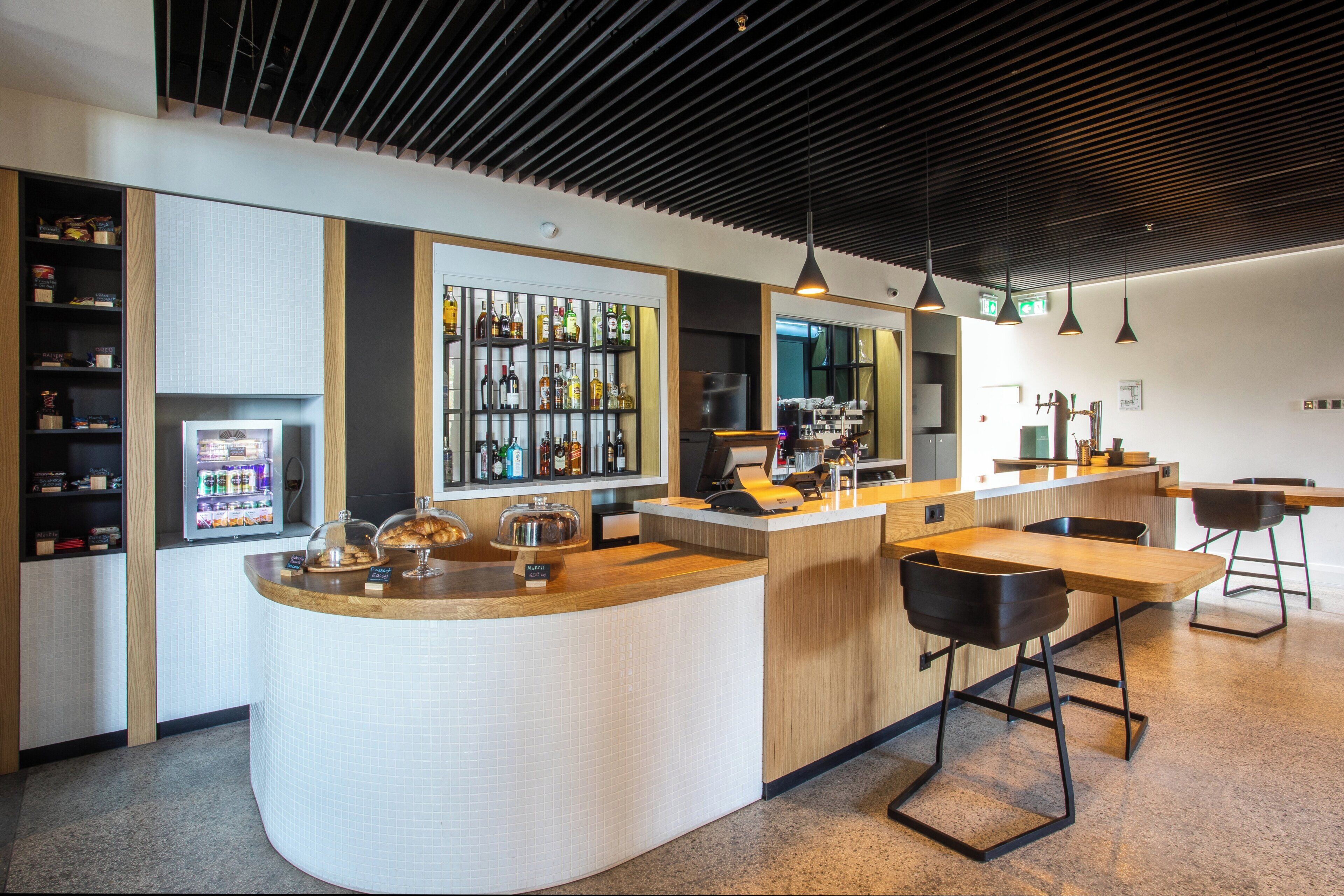 A modern kitchen with a curved island, bar area, and seating.