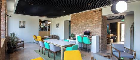 Un interior moderno con comedor, asientos y una pared decorada con ladrillo.