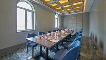A conference room with a long table, chairs, and a modern ceiling design.