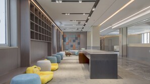 A modern conference room with a long table, cushioned seating, and a geometric wall design. - Holiday Inn Express Beijing Badaling by IHG (Yanqing)