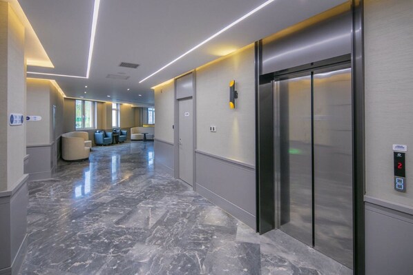 A modern elevator with a control panel and a marble floor. - Holiday Inn Express Beijing Badaling by IHG (Yanqing)