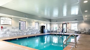 Ein hallenbad mit deutlicher Beschilderung, einer gefliesten Wand und einem Sprungverbot-Hinweis.