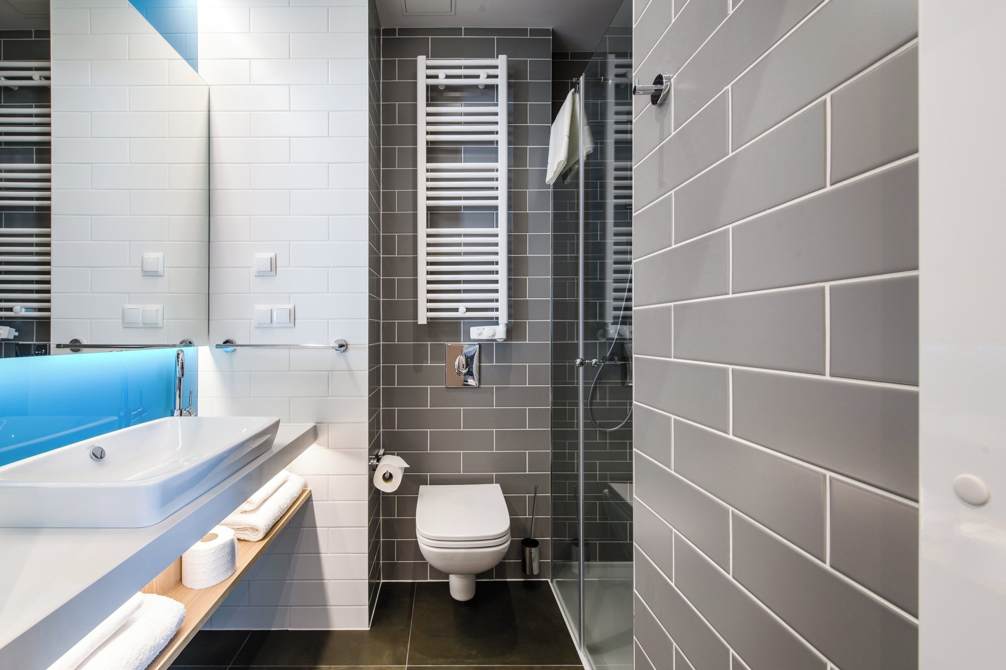 A modern bathroom with a bathtub, toilet, and shower area.