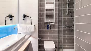A bathroom with a white sink, a toilet, and a shower area.