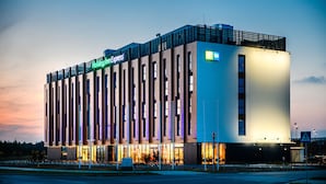 Un hôtel moderne, reconnaissable à son grand panneau « Holiday Inn Express », à sa vaste façade vitrée et à son toit plat.
