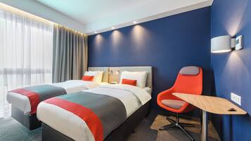 Una habitación de hotel con dos camas, un escritorio y una silla.
