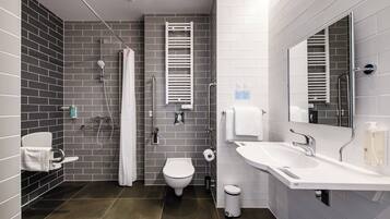 A modern bathroom with a toilet, bidet, shower, and sink.
