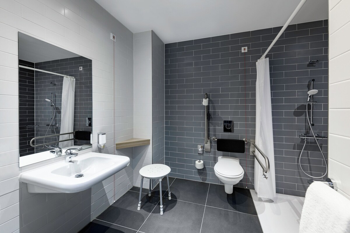 A modern bathroom with a sink, toilet, and shower.