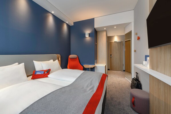 A modern hotel room with a large bed, a desk, and a seating area. - Holiday Inn Express Regensburg by IHG (Regensburg)