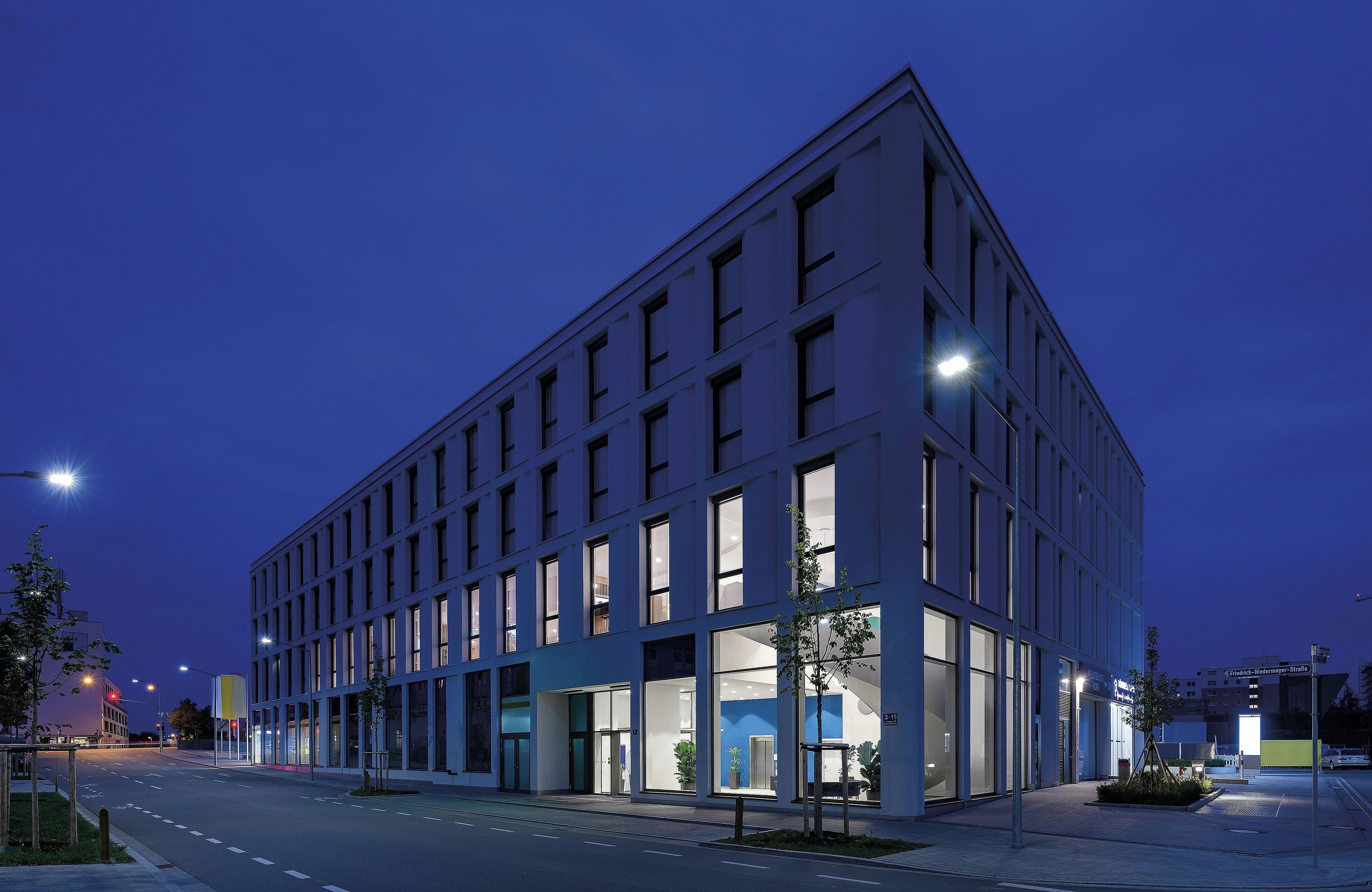 A modern building with a flat facade, large windows, and a clean, geometric design.