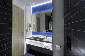 A modern bathroom with a large mirror, a sink, and a towel rack. - Holiday Inn Express Regensburg by IHG (Regensburg)