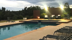 A swimming pool with lounge chairs and a brick structure in the background. - Phillip Island Nature Resort (Cowes)