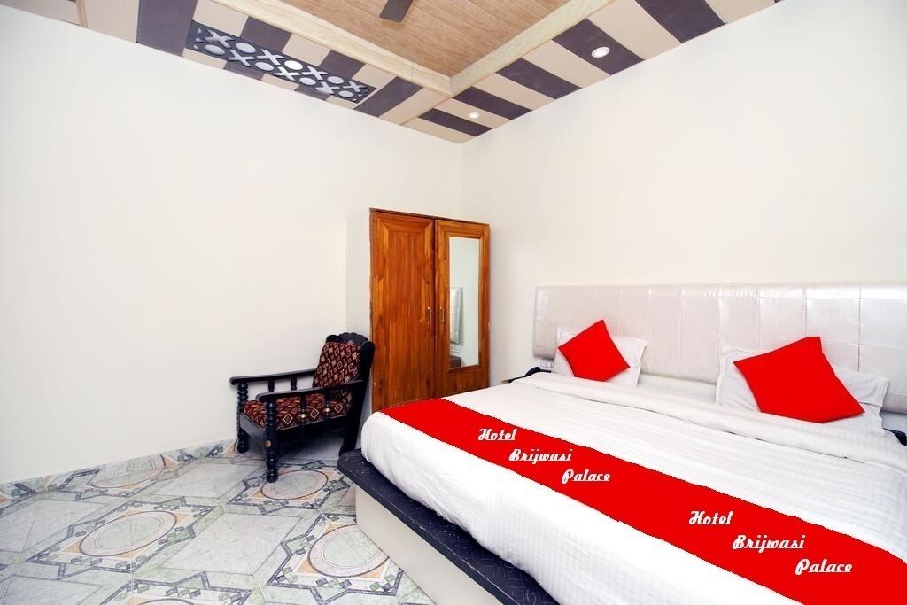 Una habitación de hotel con cama, una silla, armario y suelo estampado.