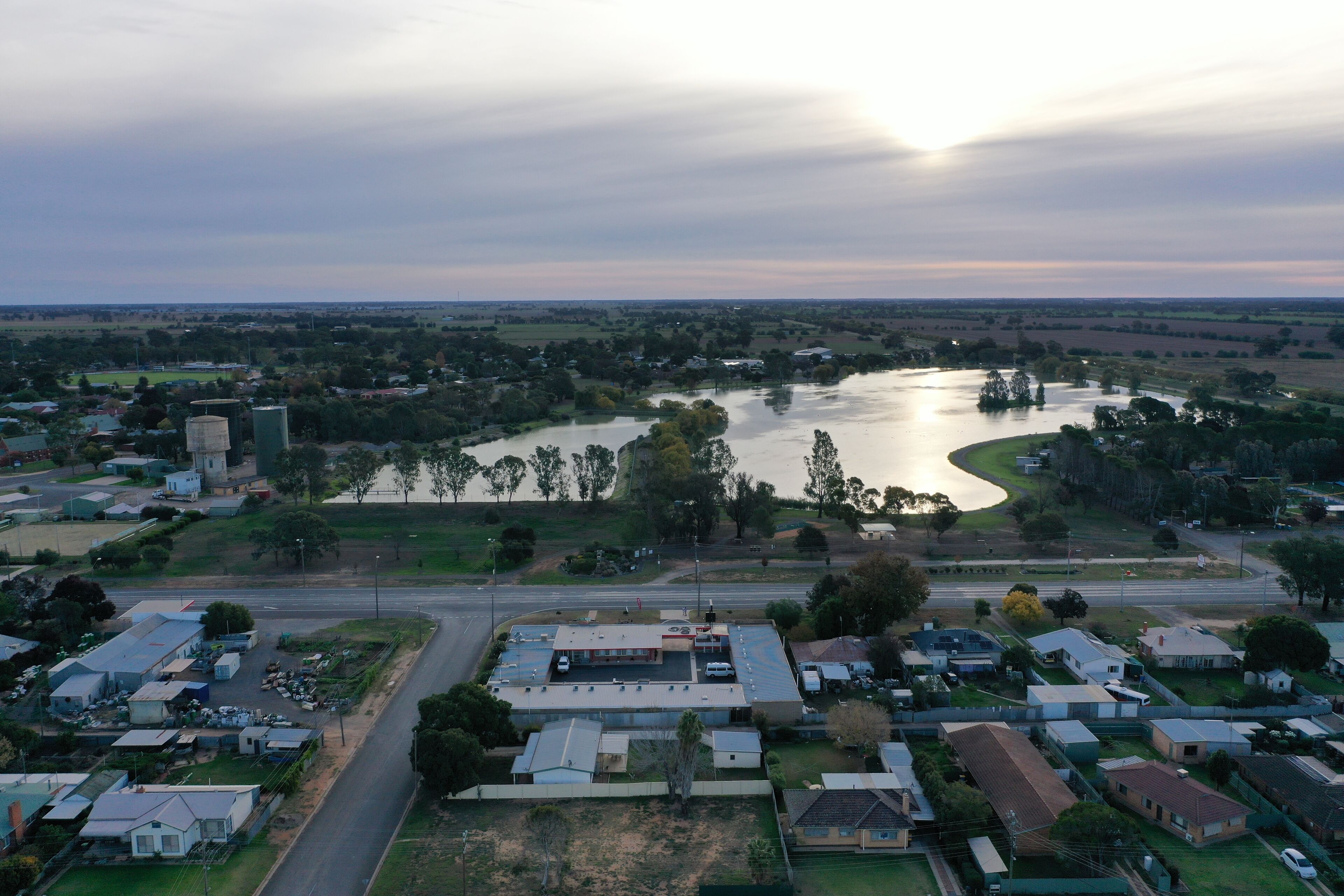 Vista aérea de un pueblo con un río, edificios y una carretera.