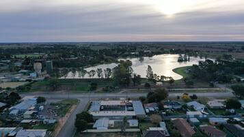 Vista aérea de un pueblo con un río, edificios y una carretera.