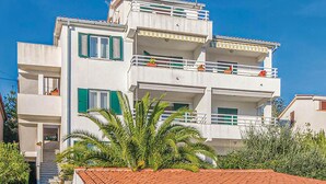 A two-story building with balconies, green shutters, and a tiled roof. - Nice studio in Rabac with house sea view (Rabac)