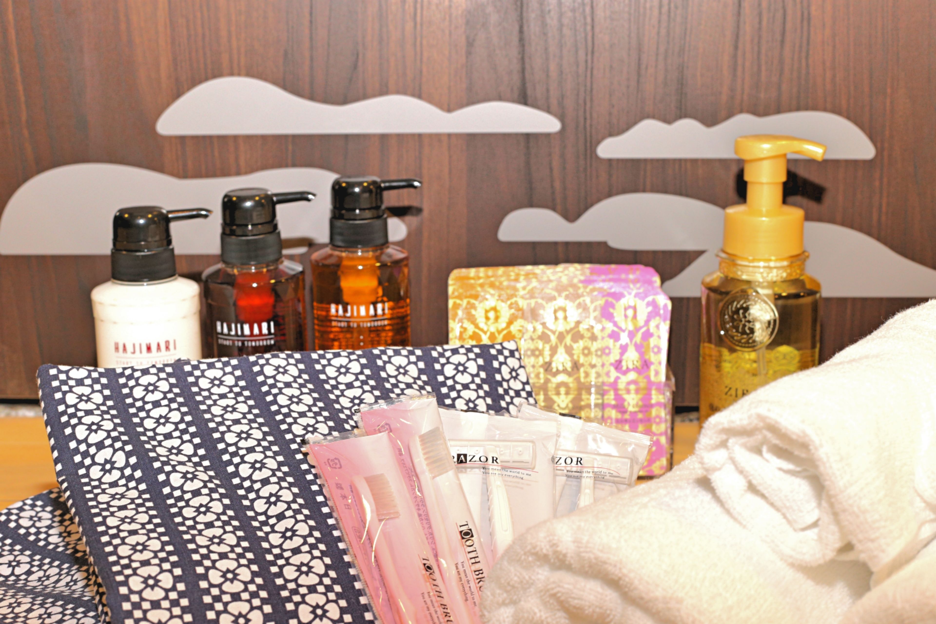 Toiletries and a towel on a hotel bed.