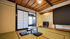 A traditional tatami mat room with a sliding door, a television, and a small table. - Setouchi Mangetsusou (Takamatsu)