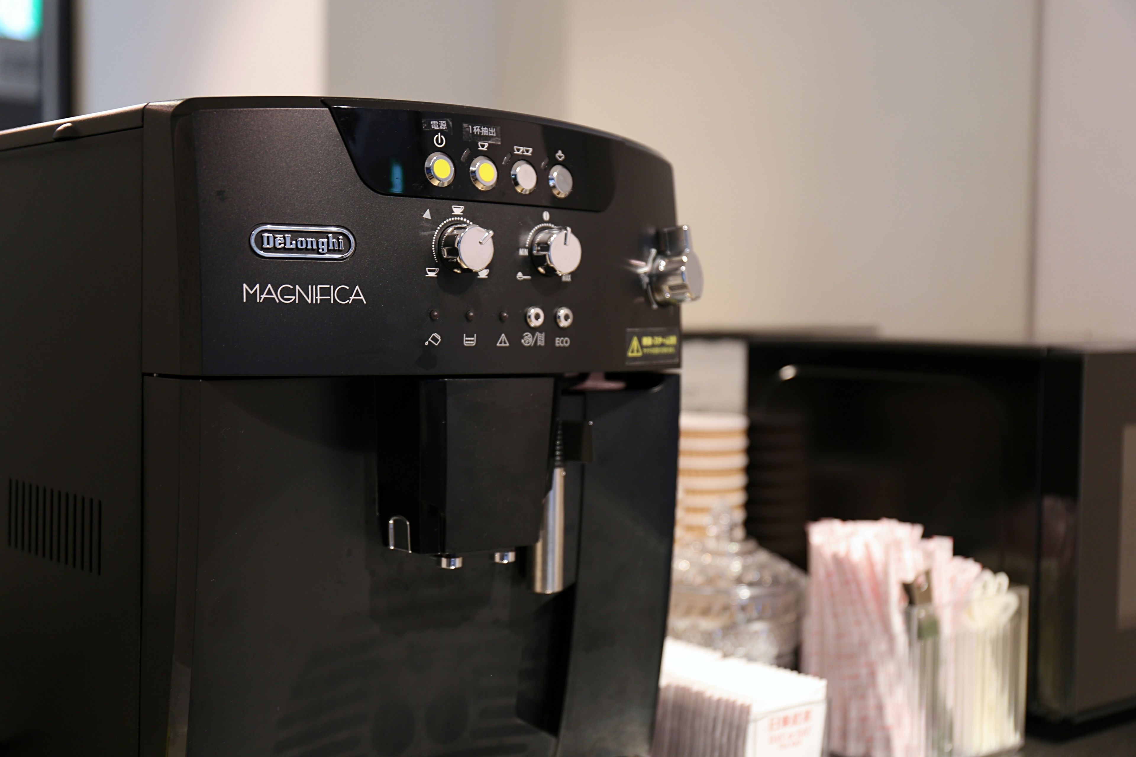 Una máquina de café espresso negra con varias perillas de control y un dispensador de agua.
