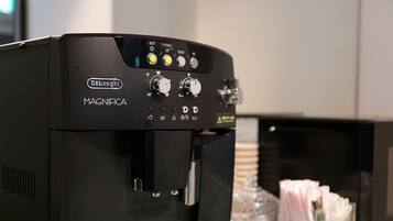 Una máquina de café espresso negra con varias perillas de control y un dispensador de agua.
